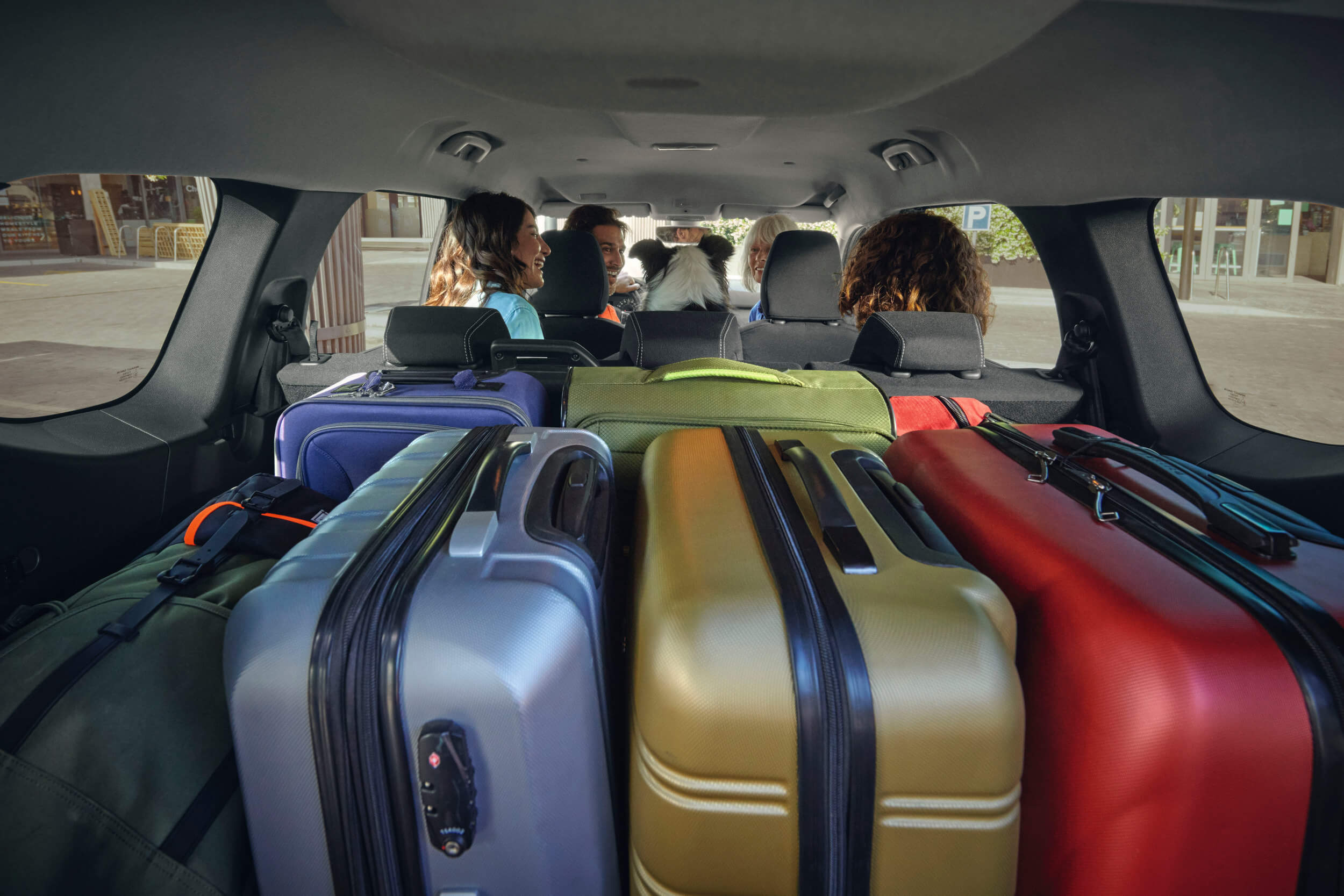 Vaizdas į Dacia Jogger interjerą iš bagažinės, kurioje sukrauti lagaminai