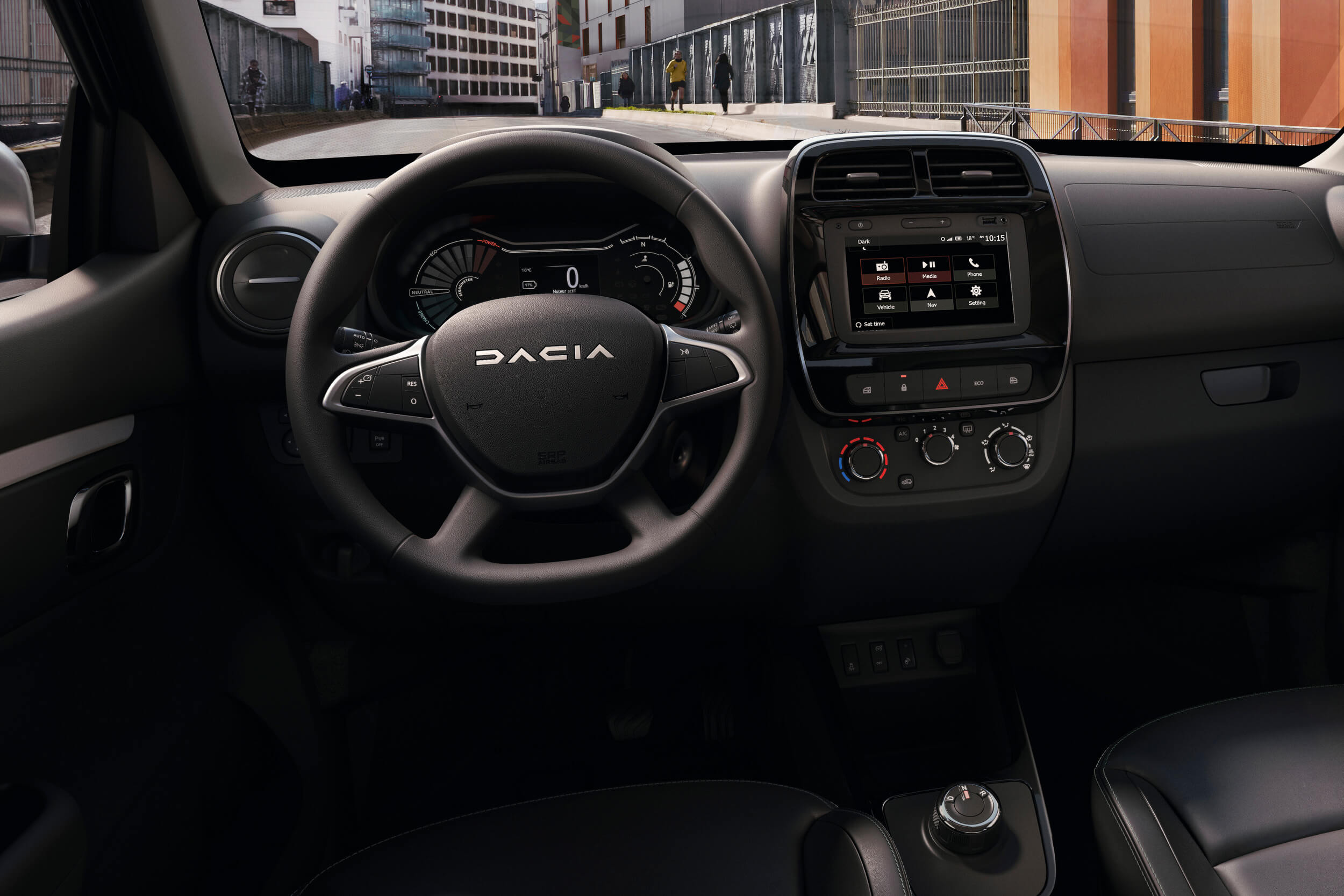 Elektrinio Dacia Spring interjeras: matomas vairas, prietaisų skydelis, centrinis ekranas ir centrinė konsolė